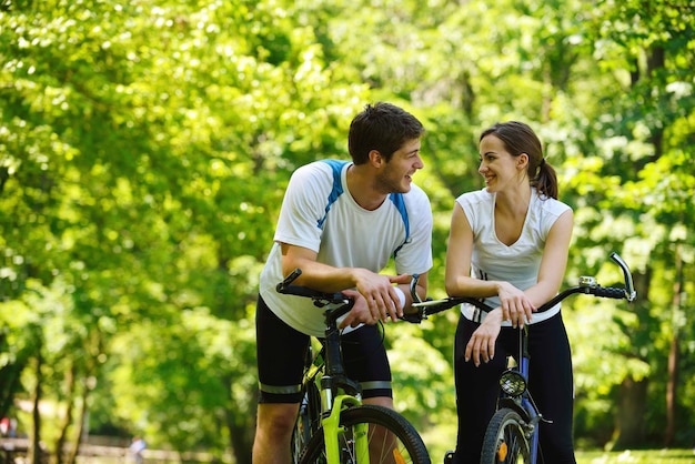 Pareja feliz andar en bicicleta al aire libre, concepto de romance de amor divertido de estilo de vida de salud