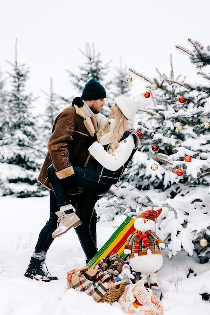 una pareja feliz arregla el árbol de navidad