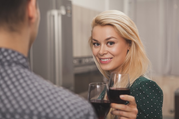 Pareja feliz bebiendo vino juntos en casa