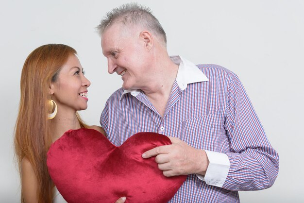 Foto una pareja feliz besándose contra un fondo blanco.