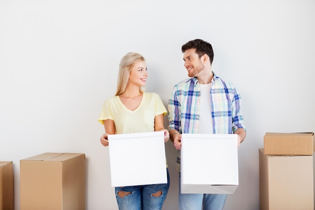 pareja feliz con cajas moviéndose a un nuevo hogar