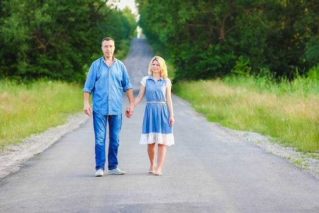 Una pareja feliz caminando por la carretera en la naturaleza en el parque