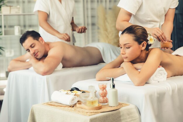 Una pareja feliz de clientes teniendo un tratamiento de exfoliación en un spa de lujo quiescente