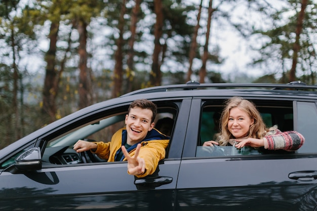 Pareja feliz en el coche en viaje por carretera