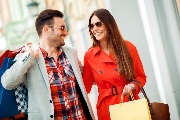 Pareja feliz de compras en la ciudad