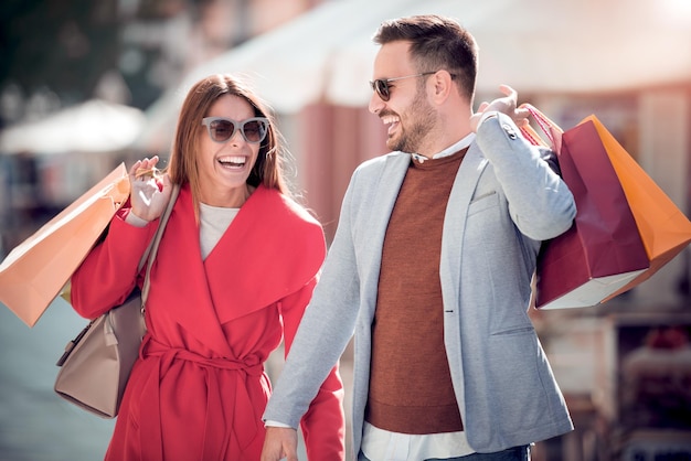 Pareja feliz de compras juntos en la ciudad