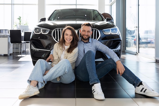 Una pareja feliz compró un auto en un concesionario de autos