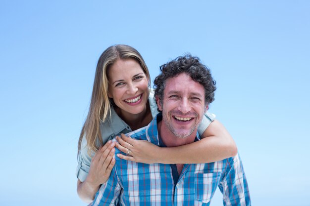 Pareja feliz contra el cielo azul claro