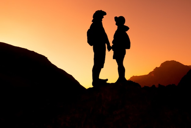 Foto pareja feliz en la cordillera en el paisaje al atardecer. montañas fann, tayikistán