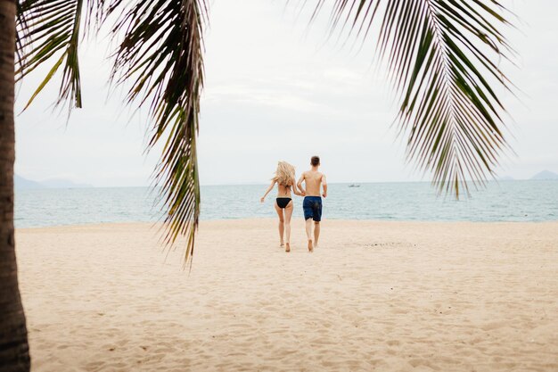 Pareja feliz corre en la playa Vista al mar y playa de arena en Asia Vietnam