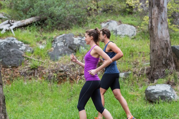 Pareja feliz corriendo en campo