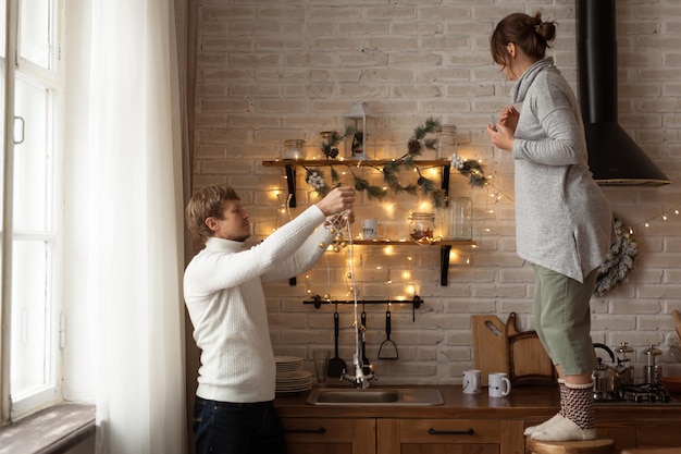 Pareja feliz decorando el hogar para la celebración de Navidad