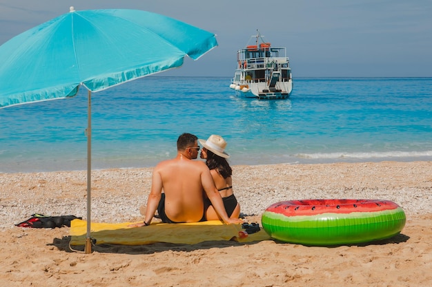 Pareja feliz descansando en la playa feliz de Grecia