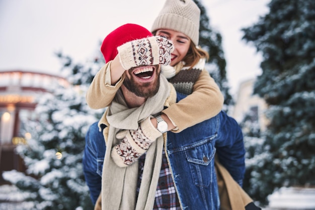 Pareja feliz disfrutando del clima nevado en el parque