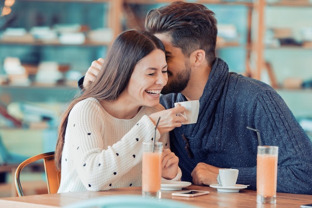 Pareja feliz divirtiéndose en el café