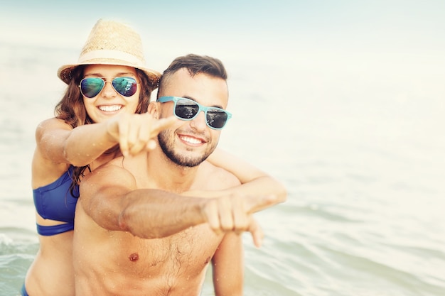 Foto pareja feliz divirtiéndose en la playa