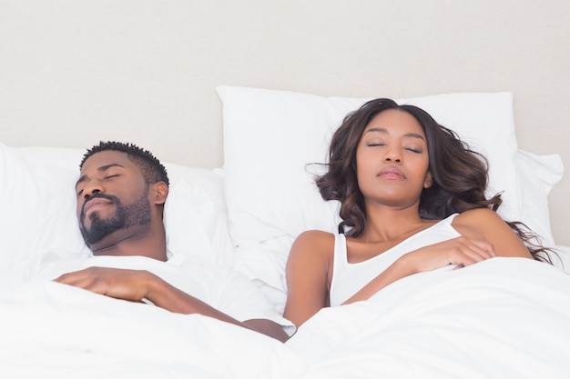 Pareja feliz durmiendo en la cama juntos