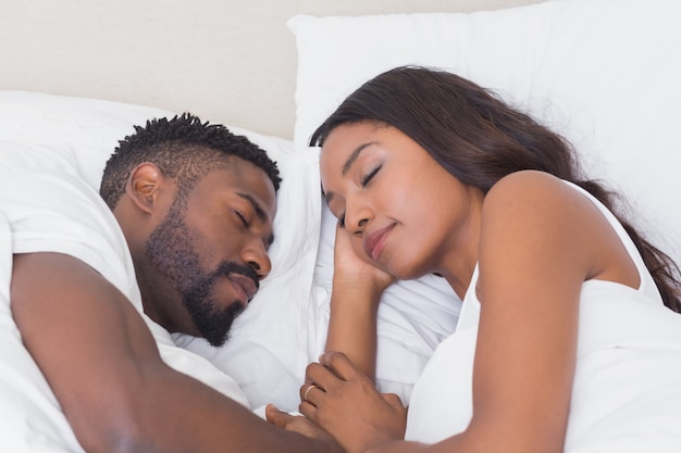 Pareja feliz durmiendo en la cama juntos