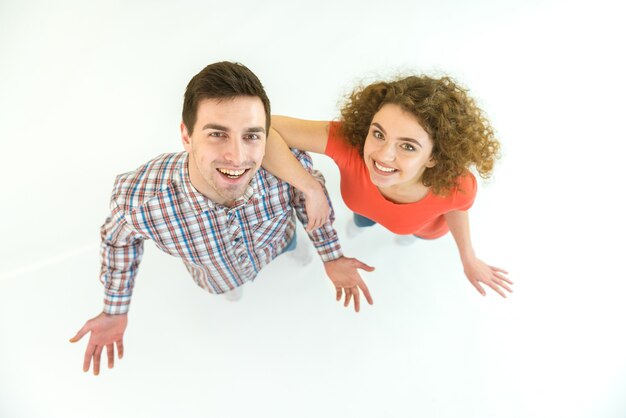 La pareja feliz está de pie sobre el fondo blanco. Vista desde arriba