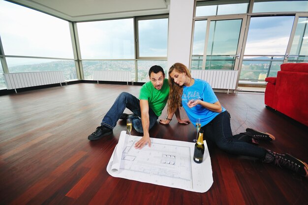 Una pareja feliz en un gran apartamento cómodo y brillante celebra con copas de champán.