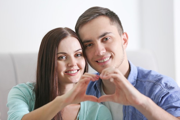 Pareja feliz haciendo corazón con las manos