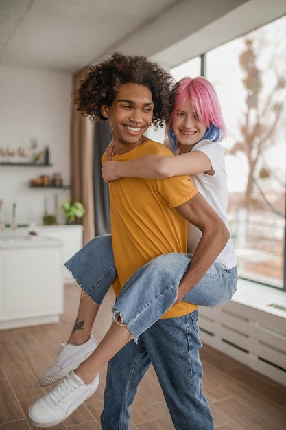 Foto pareja feliz jóvenes divirtiéndose juntos en casa y luciendo felices