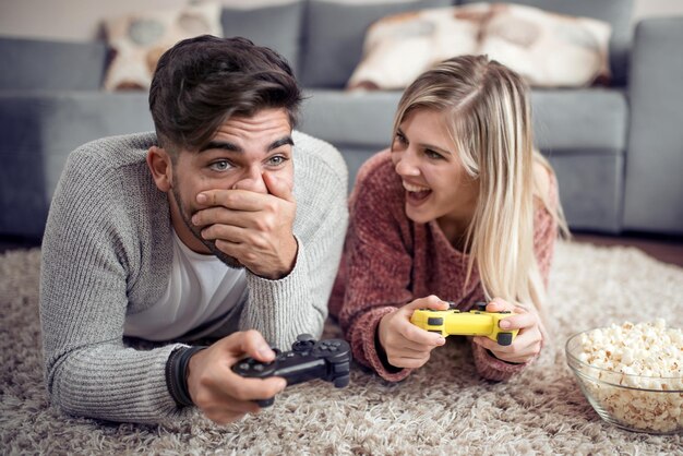 Una pareja feliz juega videojuegos en casa