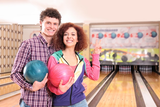 Foto pareja feliz jugando a los bolos juntos