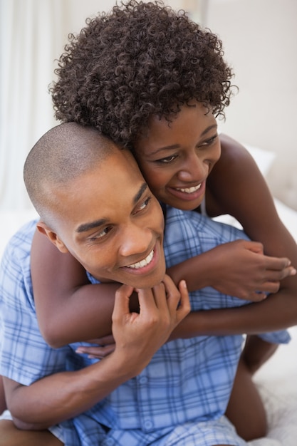 Pareja feliz jugando en la cama juntos