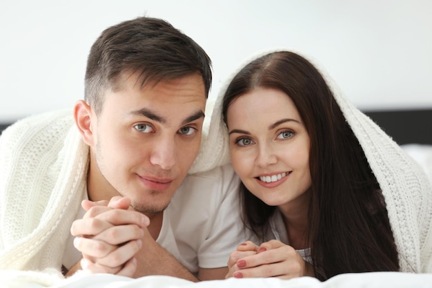 Pareja feliz juntos bajo una manta