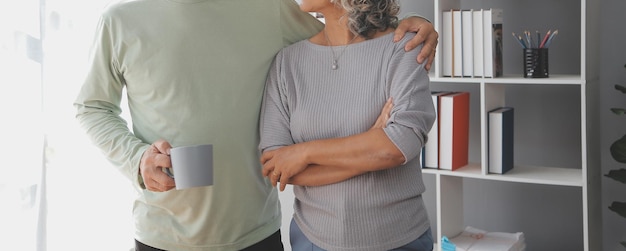 Foto una pareja feliz y madura usando una computadora portátil en casa.