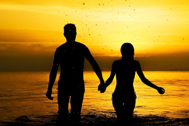 Una pareja feliz en el mar en la silueta de viaje por la naturaleza