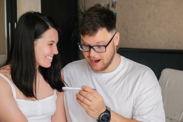 Pareja feliz mirando prueba de embarazo positiva