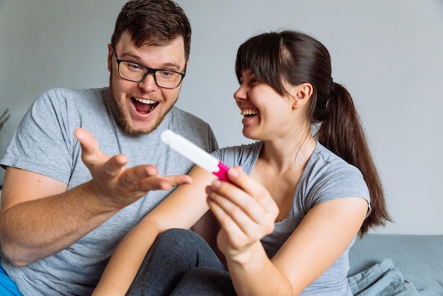 Pareja feliz mirando la prueba de embarazo