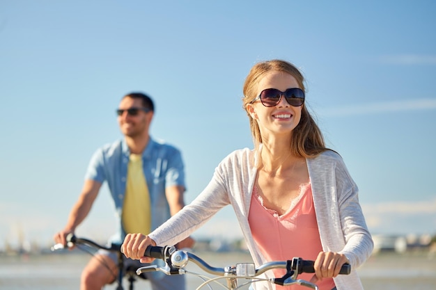 una pareja feliz montando bicicletas en la orilla del mar