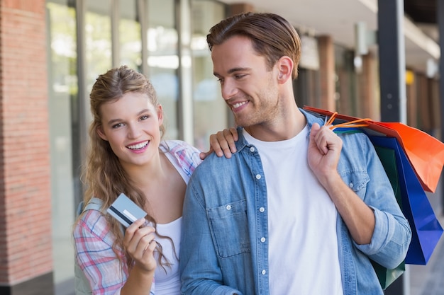 Una pareja feliz mostrando su nueva tarjeta de crédito