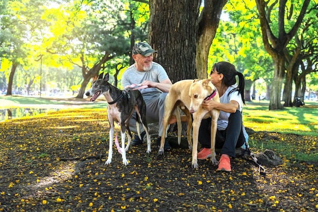 Una pareja feliz con perros en un parque