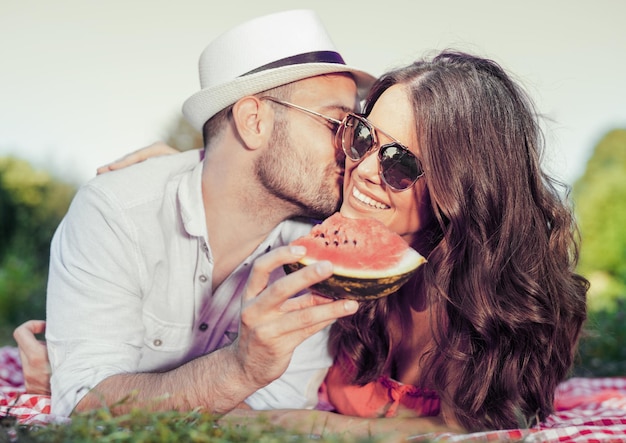 Pareja feliz en un picnic comiendo sandía