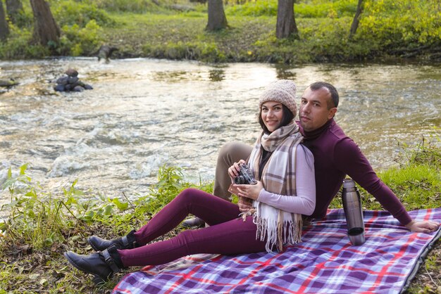 Una pareja feliz en un picnic junto al río.