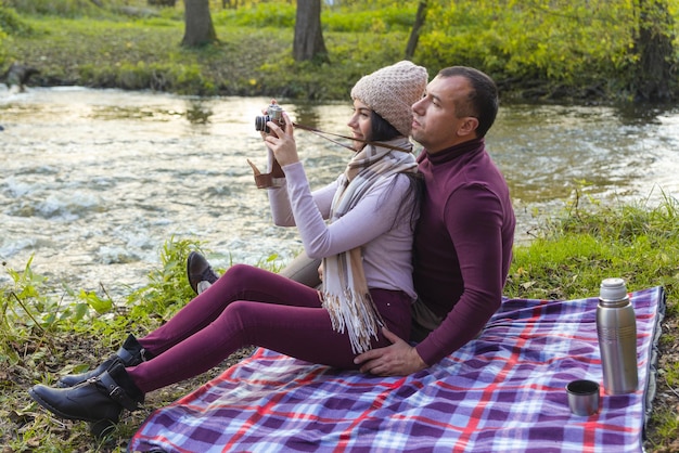 Una pareja feliz en un picnic junto al río.