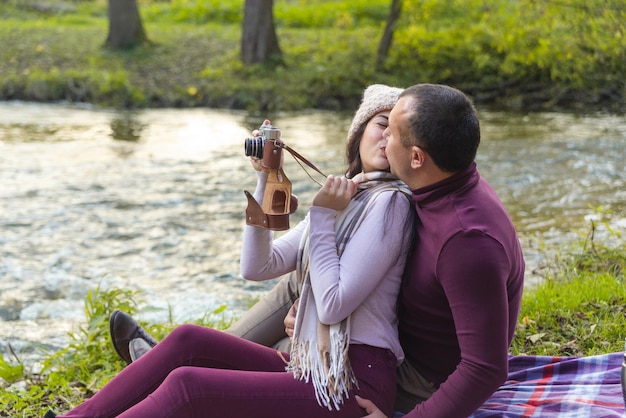 Una pareja feliz en un picnic junto al río.