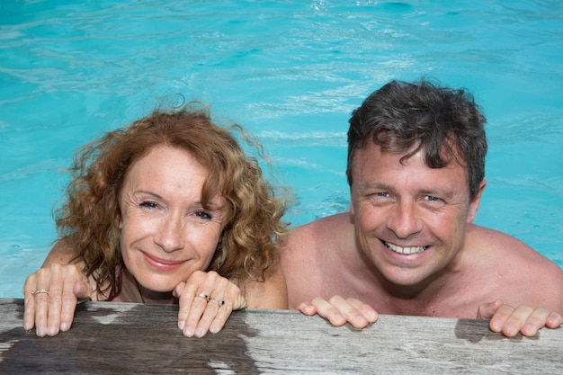 Pareja feliz en la piscina en verano