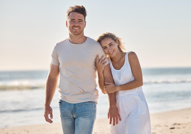 Pareja feliz y playa en retrato por amor vinculación y caminar juntos en vacaciones o luna de miel Hombre mujer y romance en caminata de aventura o relajarse junto al mar en olas de verano y sonrisa