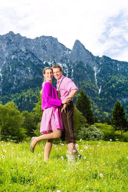 Pareja feliz en prado alpino