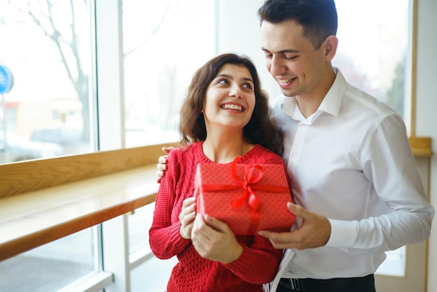 Pareja feliz con regalo abrazando Caja de regalo roja en manos de una pareja enamorada Día de San Valentín