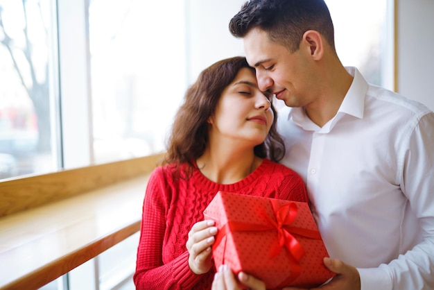 Pareja feliz con regalo abrazando Caja de regalo roja en manos de una pareja enamorada Día de San Valentín