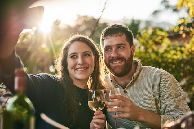 Foto pareja feliz selfie y vino en la granja de vinos de viñedos y sonrisa en vacaciones y al aire libre mujer hombre y copa de vino en foto digital bajo el sol de verano juntos y amor en marsella francia