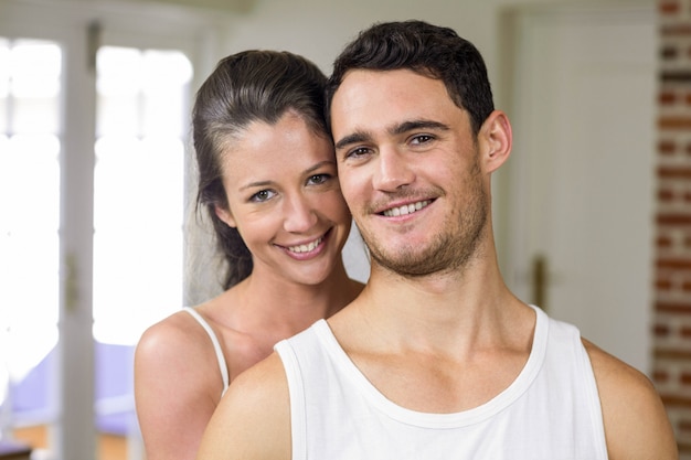 Pareja feliz sonriendo a la cámara en la cocina