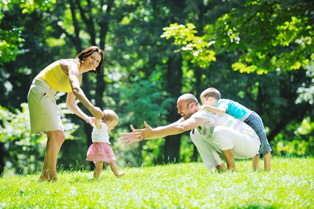 Una pareja feliz con sus hijos se divierten en el parque.
