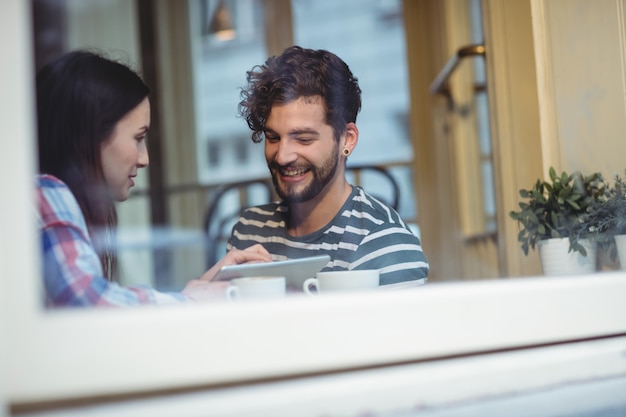 Pareja feliz con tablet pc en café